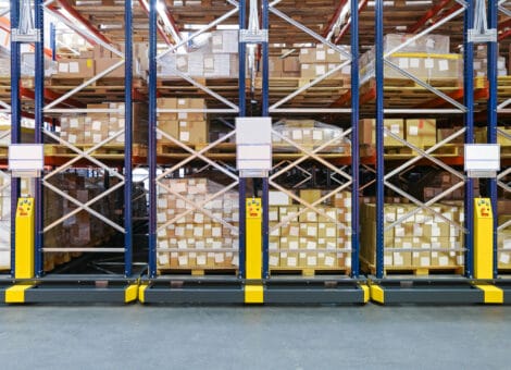 Warehouse aisle with cardboard boxes on shelves.