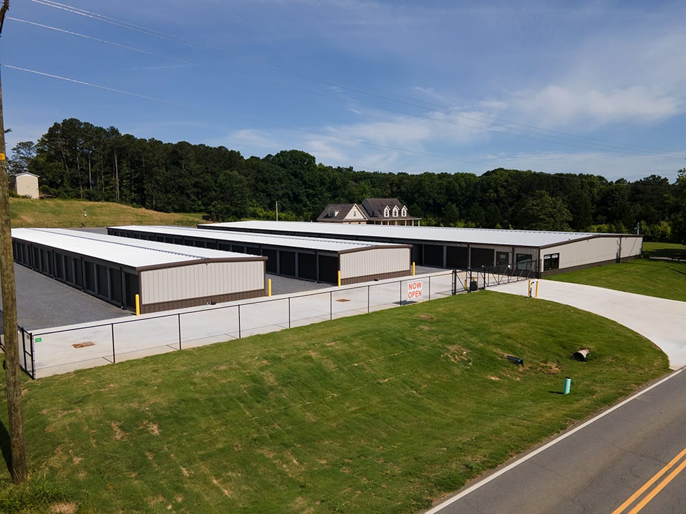 Steel mini storage buildings with landscaping, fence, and driveway